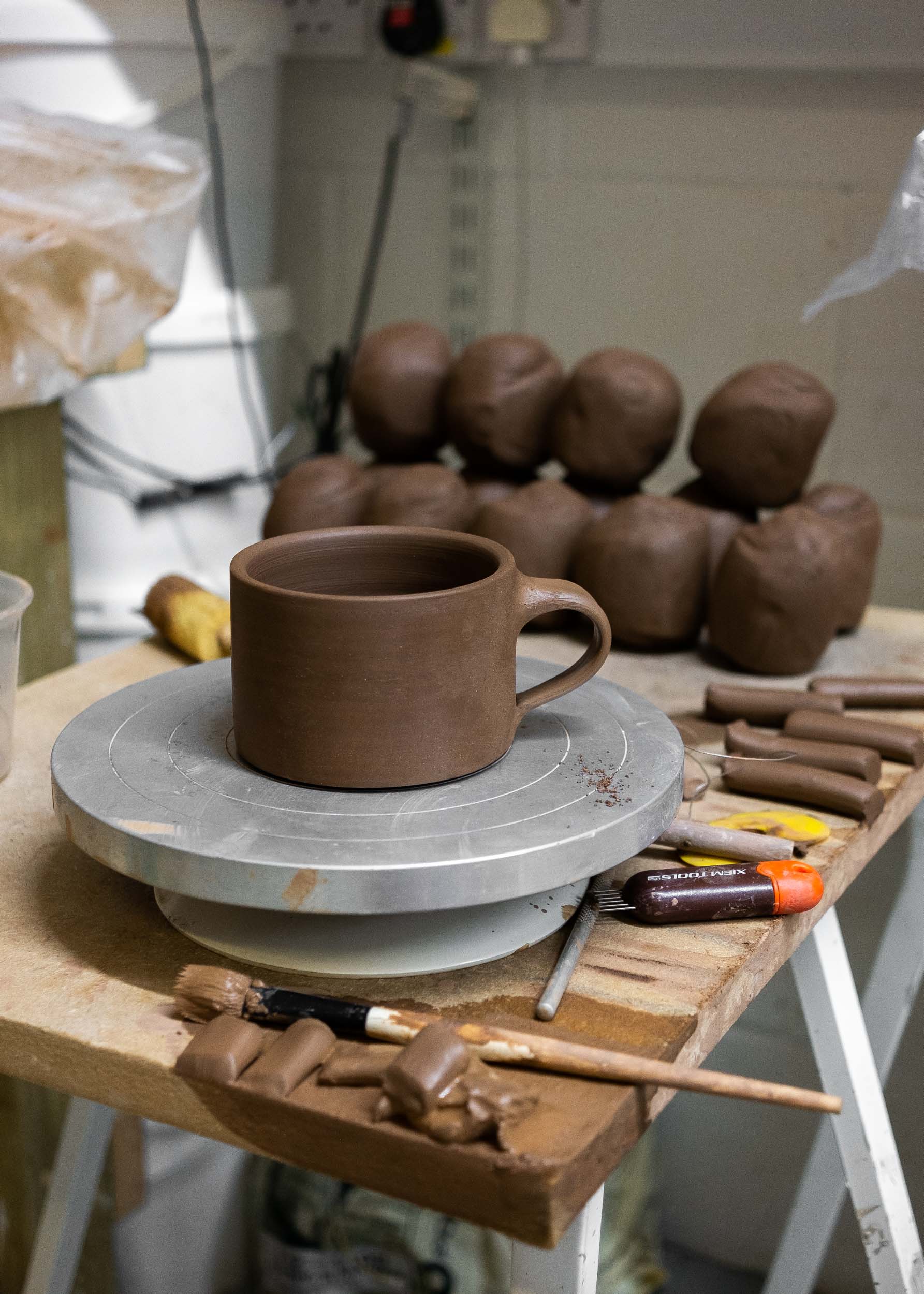 Dark clay mug on a banding wheel